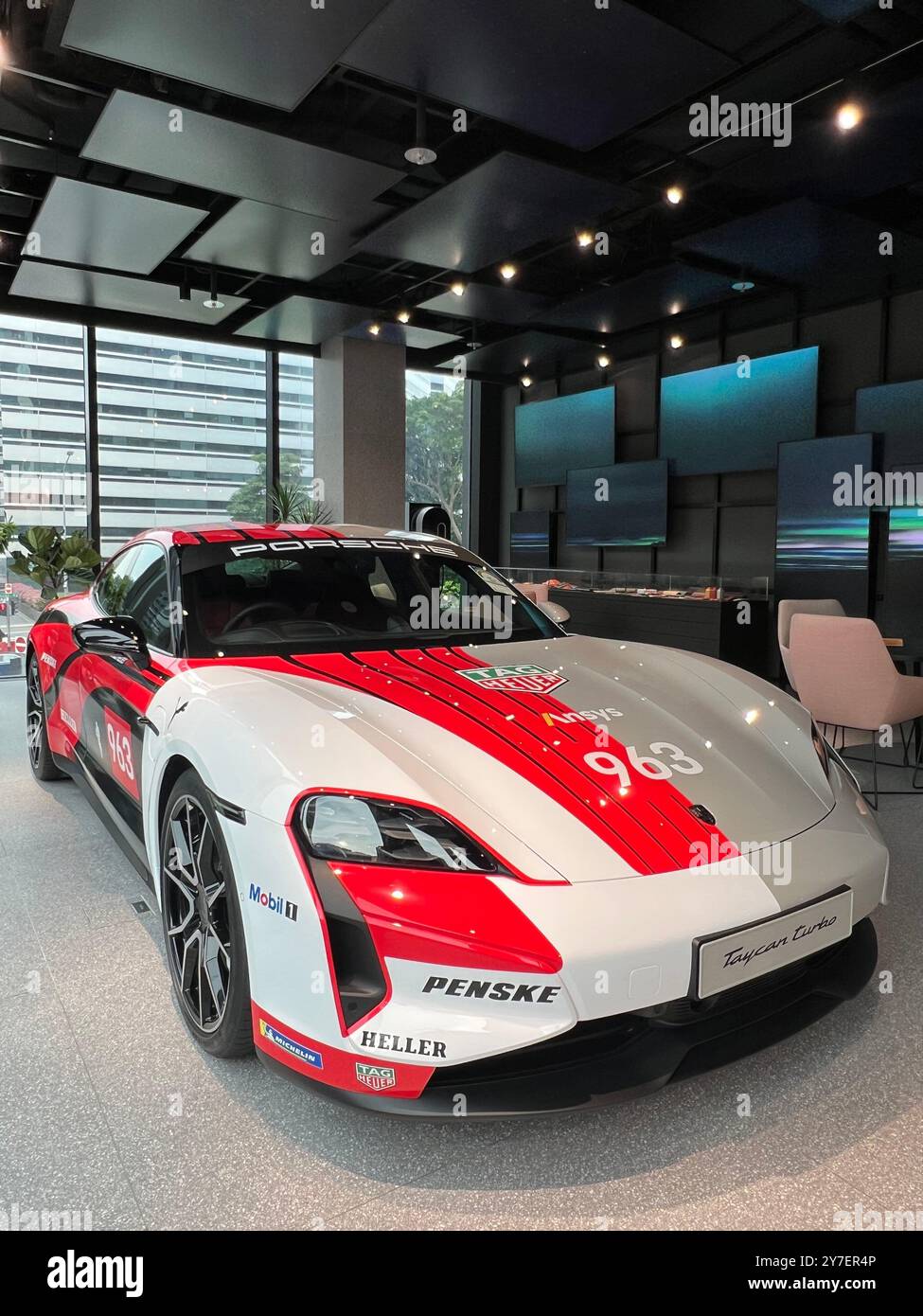 Verticale. Auto Porsche Taycan Turbo da corsa in mostra nello studio Porsche, una potente macchina elettrica realizzata per l'acquirente ricco e ricco. Singapore. - Immagine stock catturata con smartphone