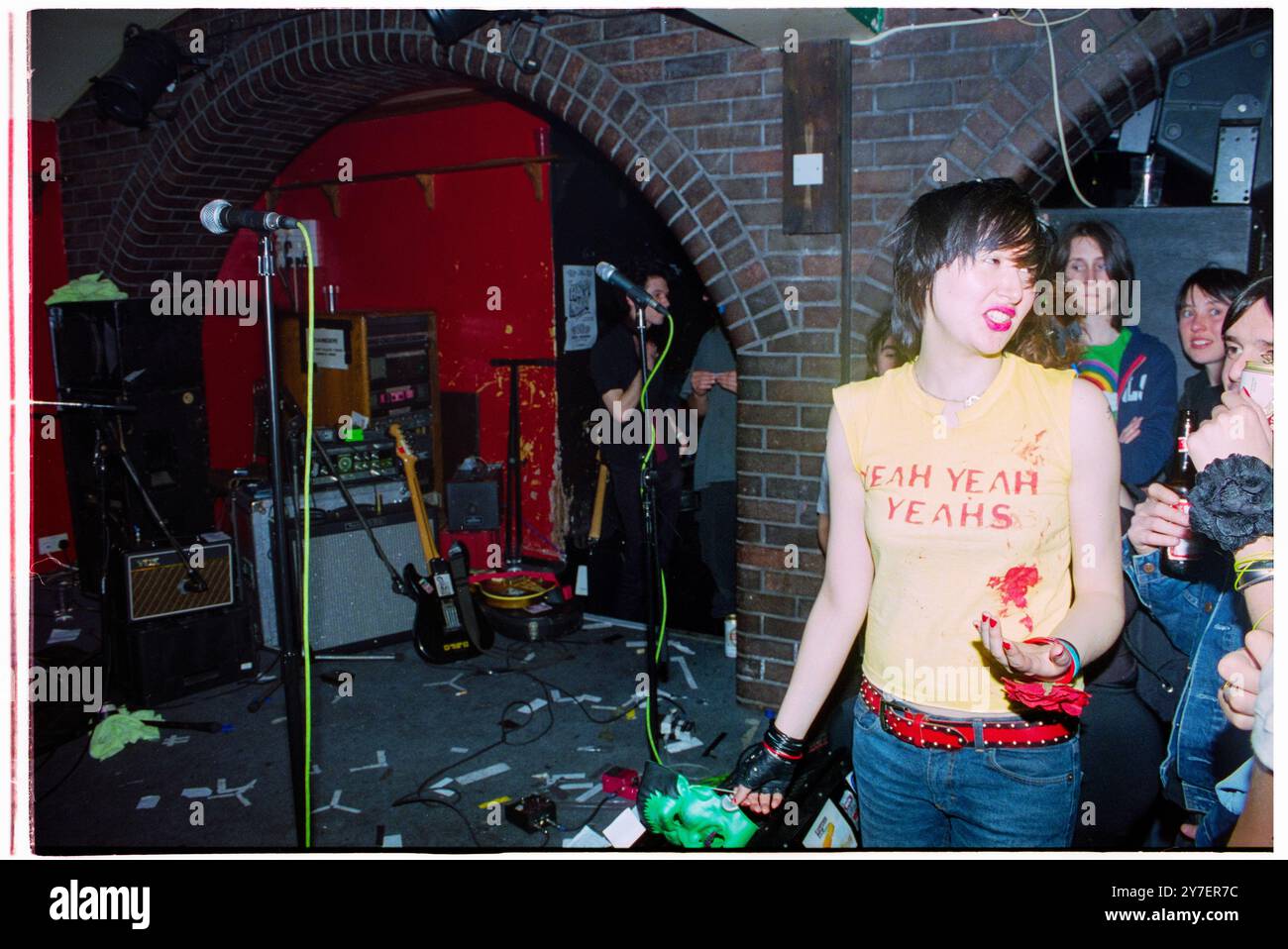 KAREN o, YEAH YEAH YEAHS, PRIMO TOUR nel Regno Unito, 2002: Una giovane Karen o di Yeah Yeah Yeahs si erge davanti alla folla prima di suonare un piccolo concerto sudato nel loro primo tour nel Regno Unito al Barfly Club di Cardiff, Galles, Regno Unito, il 21 aprile 2002. Foto: Rob Watkins. NFO: Yeah Yeah Yeahs è un gruppo musicale indie rock statunitense formatosi nel 2000, noto per il loro energico sound art-punk. Guidati dalla carismatica cantante Karen o, hanno guadagnato fama con successi come "Maps" e "Heads Will Roll", che fondono il rock grezzo del garage con la profondità emotiva. Foto Stock