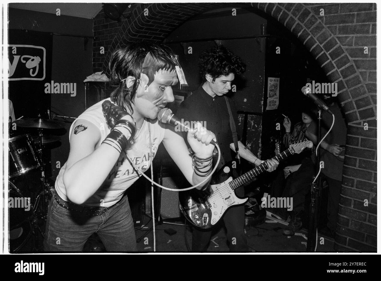 KAREN o, YEAH YEAH YEAHS, PRIMO TOUR nel Regno Unito, 2002: A Young Karen o of Yeah Yeah Yeahs si esibisce in un film horror Frankenstein mask suonando un piccolo concerto sudato nel loro primo tour nel Regno Unito al Barfly Club di Cardiff, Galles, Regno Unito, il 21 aprile 2002. Foto: Rob Watkins. NFO: Yeah Yeah Yeahs è un gruppo musicale indie rock statunitense formatosi nel 2000, noto per il loro energico sound art-punk. Guidati dalla carismatica cantante Karen o, hanno guadagnato fama con successi come "Maps" e "Heads Will Roll", che fondono il rock grezzo del garage con la profondità emotiva. Foto Stock