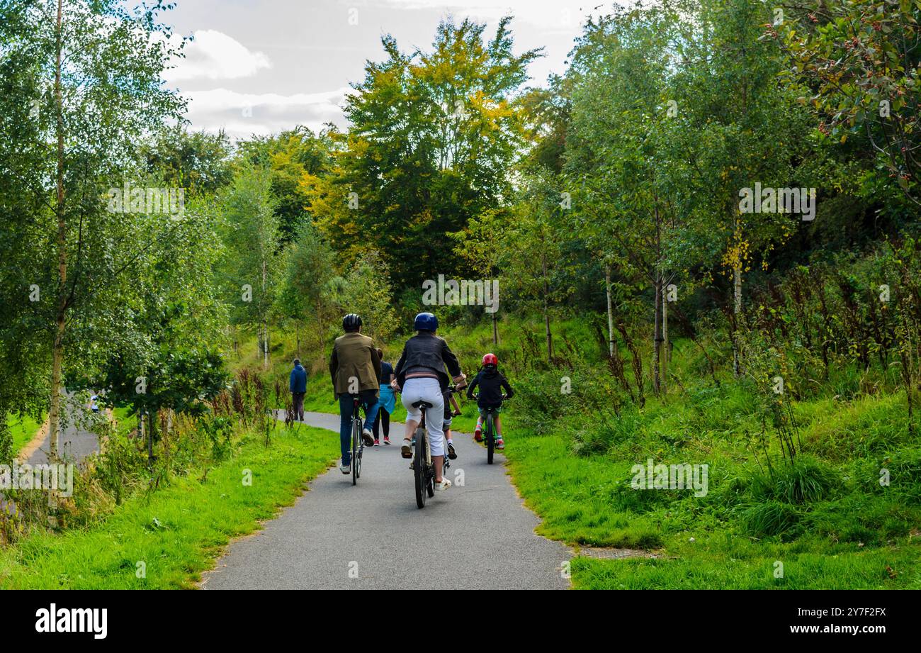 Belfast, Contea di Down, Irlanda del Nord 15 settembre 2024 - Una famiglia in gita in bicicletta sul sentiero della città lungo il fiume Lagan a Stranmillis, da cui proviene Foto Stock