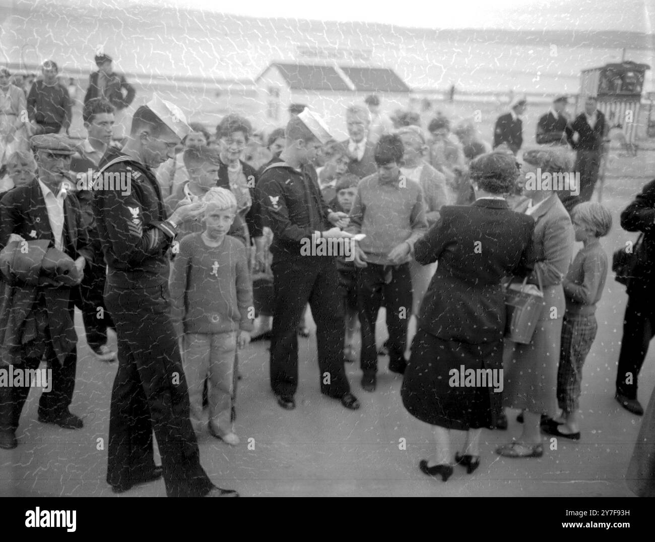 Weymouth, Dorset, due membri dell'equipaggio del sottomarino a propulsione nucleare Nautilus della Marina degli Stati Uniti furono assediati dai cacciatori di autogragh mentre facevano una passeggiata a Weymouth. Sono John Zaretki, di Birmingham, Alabama, e Harry Thomas, di Emporium, Pennsylvania. In precedenza loro e i loro compagni membri dell'equipaggio del nautilus avevano dato un benvenuto tumultuoso nella vicina Portland, dove il sottomarino atomico aveva sbarcato per la prima volta dal suo storico viaggio sotto la calotta glaciale del North Polar. 13 agosto 1958. Foto Stock