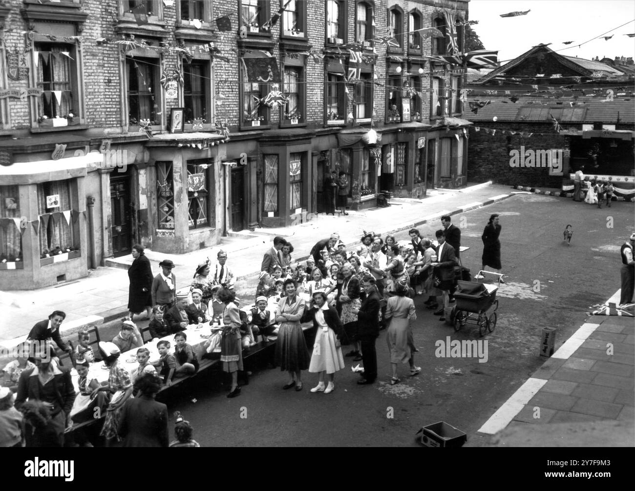 Festa in Rillington Place, il 6 giugno 1953 di fronte al decorato, salito su 10 Rillington Place, Notting Hill, i bambini si sistemano per guardare un intrattenimento dopo la festa di Coronation Street. Fu in questa casa che furono scoperti i corpi di diverse donne assassinate, e un ex residente della casa, John Reginald Halliday Christie, è ora in attesa di processo con l'accusa di aver ucciso due donne. Foto Stock