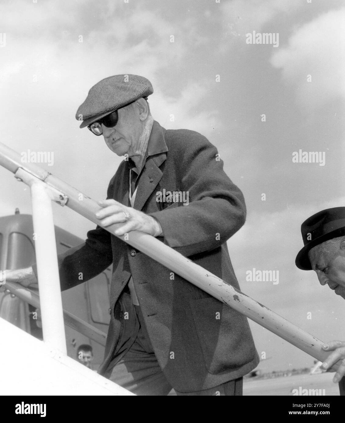 IL DIRETTORE DEL FILM JOHN FORD SI IMBARCA SU UN AEREO DIRETTO A LOS ANGELES PER TORNARE A CASA PER IL TRATTAMENTO DELL'INFEZIONE ALLA GOLA. 4 AGOSTO 1964 DUBLINO Foto Stock