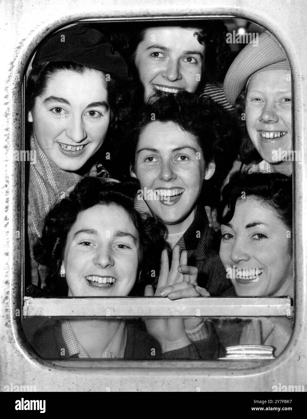 Volontari britannici per la nuova Zelanda WAAF. Una grande avventura per queste ragazze incorniciate nella finestra di una carrozza ferroviaria, mentre lasciano la stazione di Waterloo Londra, Foto Stock