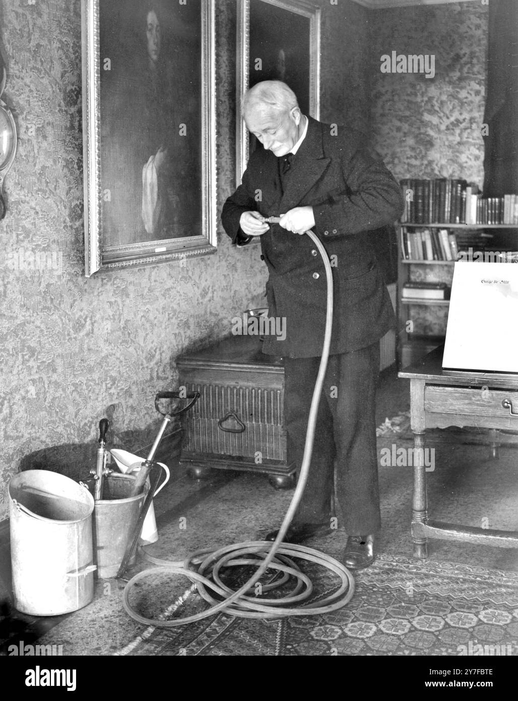 I vigili del fuoco e i guardiani hanno addestrato il pubblico all'uso di pompe a staffa. Qui il poeta laureato, John Masefield, stava imparando ad usare l'ugello che poteva essere regolato per spruzzare una bomba incendiaria o per dirigere un jet contro un incendio. Erano necessarie tre persone: Una usava la bocchetta, una faceva il pompaggio e una prendeva acqua fresca. Foto Stock