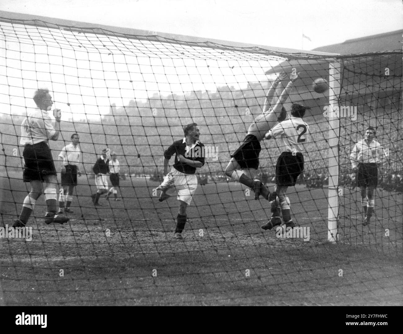 Scozia contro Inghilterra Bert Williams portiere inglese strettamente supportato dal suo capitano Billy Wright, schiena sinistra e destra Alf Ramsey (2) si schianta all'indietro per salvare da un attacco scozzese guidato dal centrocampista Willie Bauld ( dark shirt center ) nella partita internazionale a Hampden Park Glasgow. A destra c'è l'interno sinistro Roy Bentley del Chelsea che ha segnato l'unico gol della partita per dare all'Inghilterra la vittoria e il campionato internazionale il 16 aprile 1950 Foto Stock