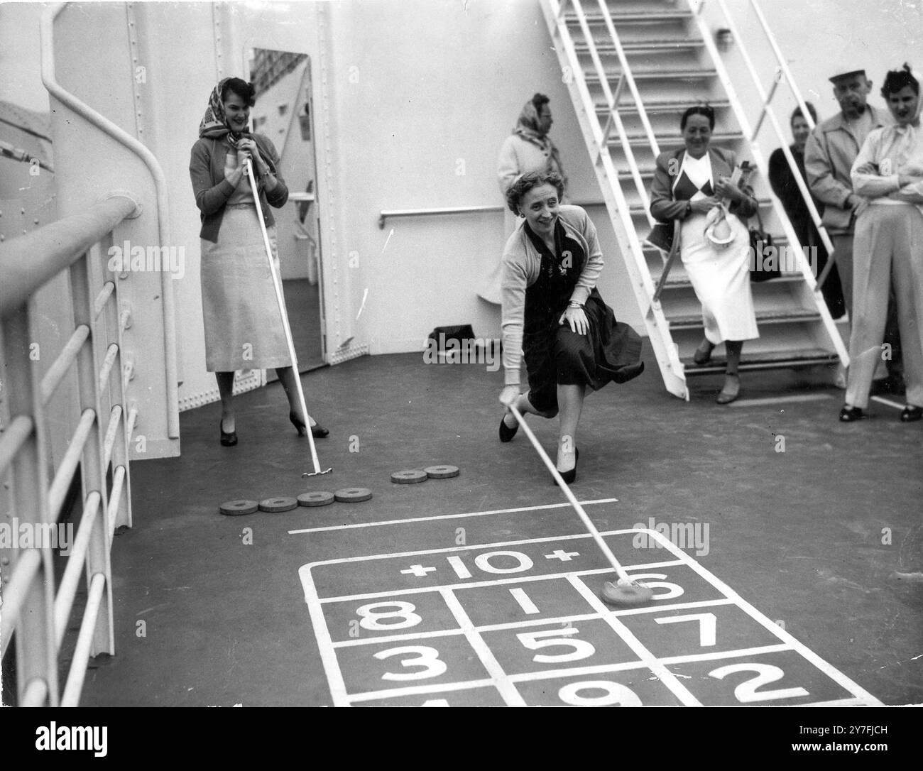 La signorina Margaret Truman, figlia del presidente americano, gioca a shuffleboard sulla linea americana "Stati Uniti" durante il suo viaggio inaugurale da New York. Sulla sinistra c'è la signora Trumans chaperone, la signora Horton, figlia del Segretario al Tesoro Degli Stati Uniti, signor Snyder. 8 luglio 1952 Foto Stock