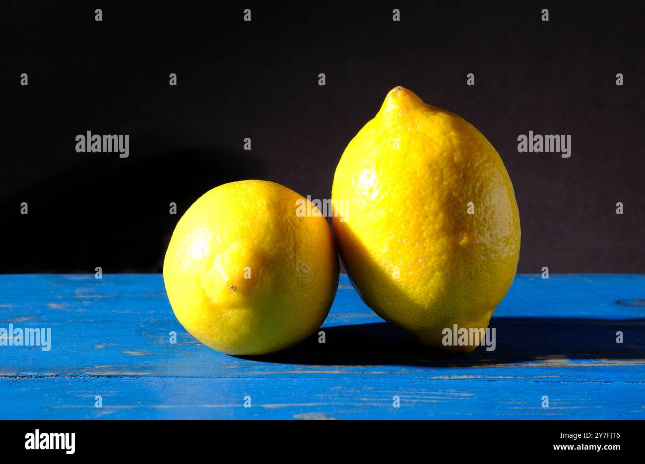 limoni gialli su un piano da tavolo dipinto di blu Foto Stock