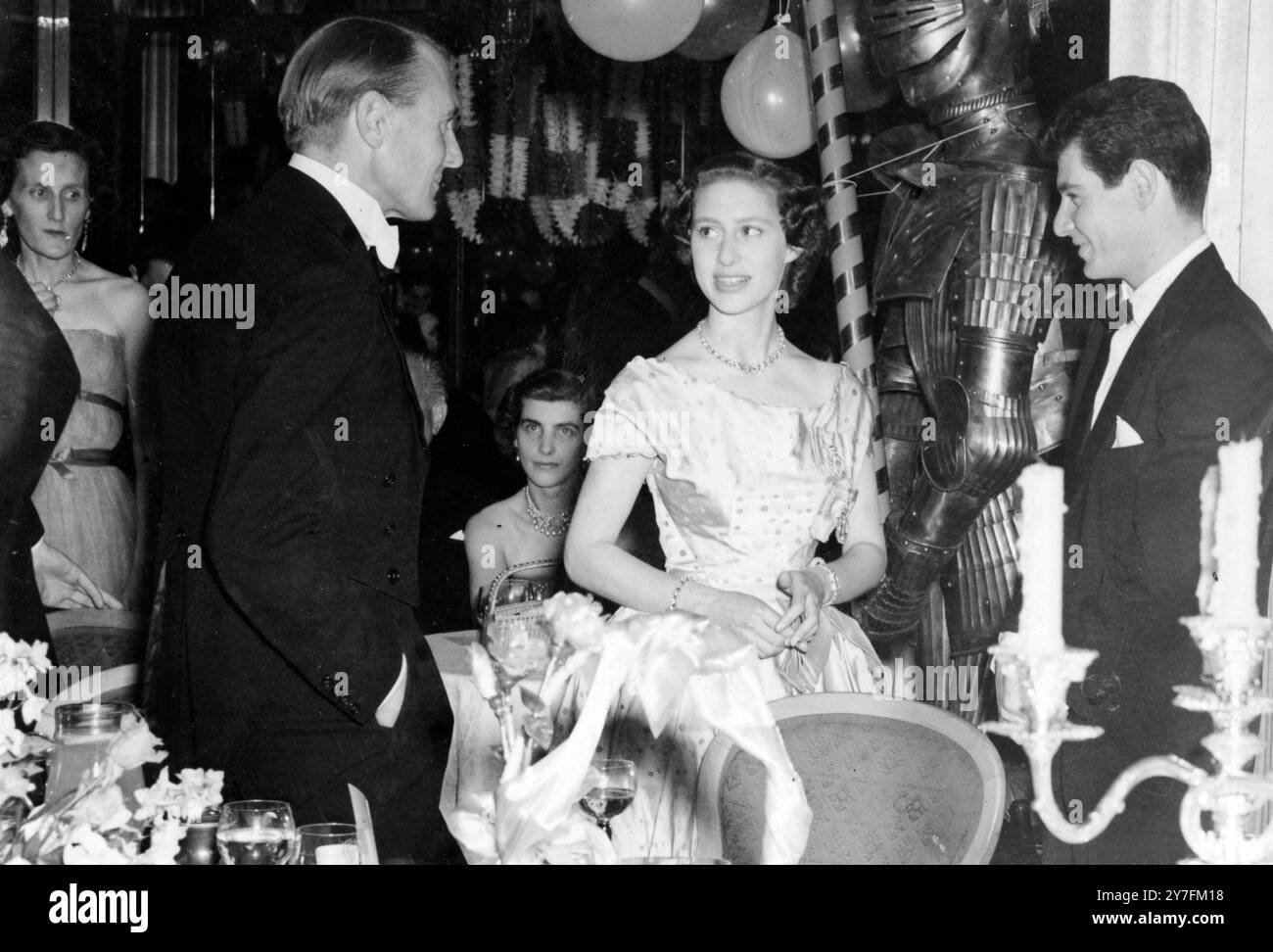 Il cantante americano Eddie Fisher (a destra) e ospite non identificato che chiacchiera con la Principessa Margaret, durante il Red White and Blue Ball tenutosi al Dorchester Hotel di Londra. Si dice che la principessa sia una "fan" di Fisher: Il suo disco preferito è "Outside of Heaven". Fisher ha cantato per 45 minuti al ballo, dedicando ' Outside of Heaven' alla Principessa. Si dice che la Principessa abbia inviato un messaggio alla cantante dicendo: "Non faremo tanto rumore come fanno al Palladium, ma lo ameremo allo stesso modo". Dopo che le canzoni Eddie fu presentato alla principessa e loro chatt Foto Stock