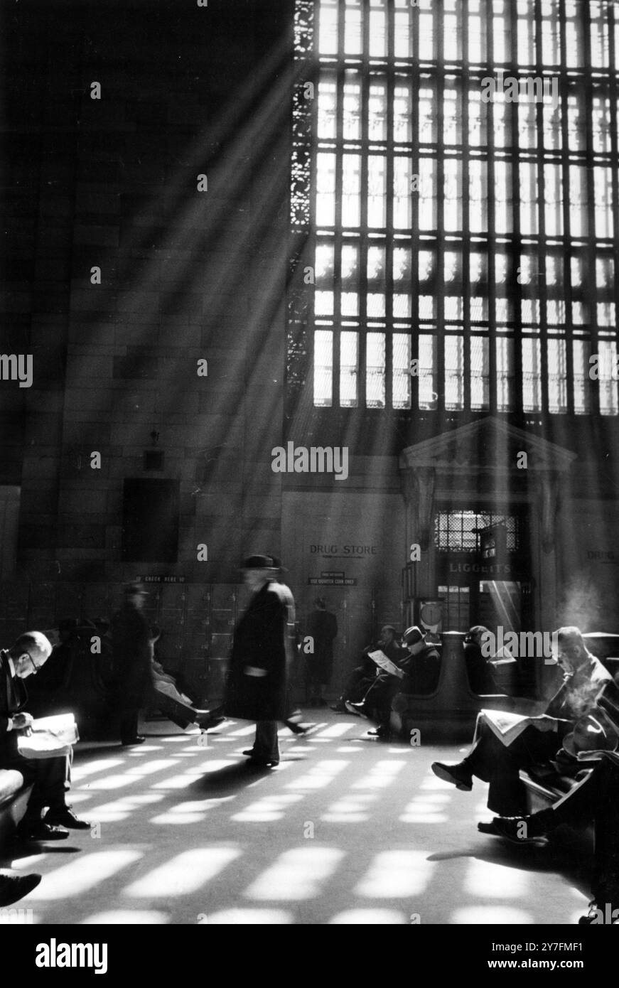 I viaggiatori aspettano pazientemente tra i treni sull'atrio principale della Grand Central Station, l'edificio ferroviario più iconico d'America, in e 42nd Street, New York, nel 1952. Foto Stock