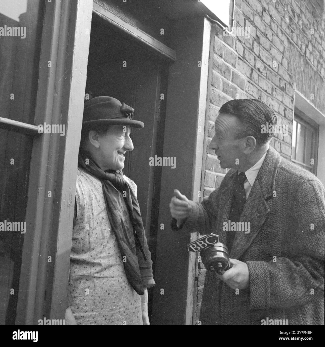 Wilfred Pickles, attore, emittente e personalità. 1904-1978. Nato nello Yorkshire, è stato un giornalista della BBC negli anni '1940 e il primo ad avere un accento regionale. Immensamente popolare negli anni '1950 e '60 con programmi radiofonici e televisivi, e come attore teatrale e cinematografico. Qui sta intervistando londinesi nativi per un programma televisivo sulla vita in città. Fotografia di George Douglas Foto Stock