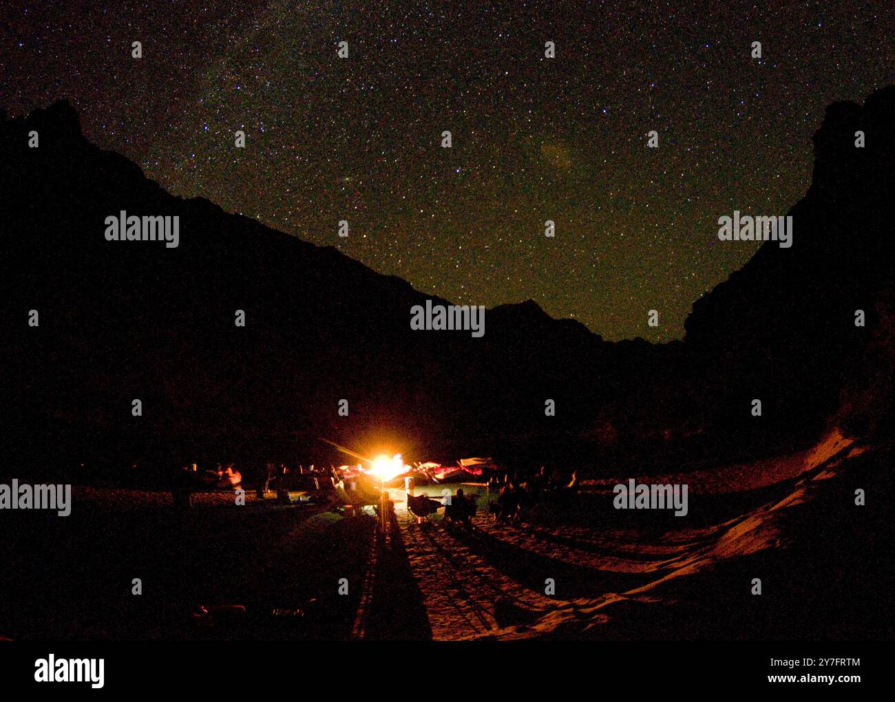 Le travi trascorrono una serata di relax accanto al fuoco sotto il cielo stellato, dopo una lunga giornata di rafting. Foto Stock