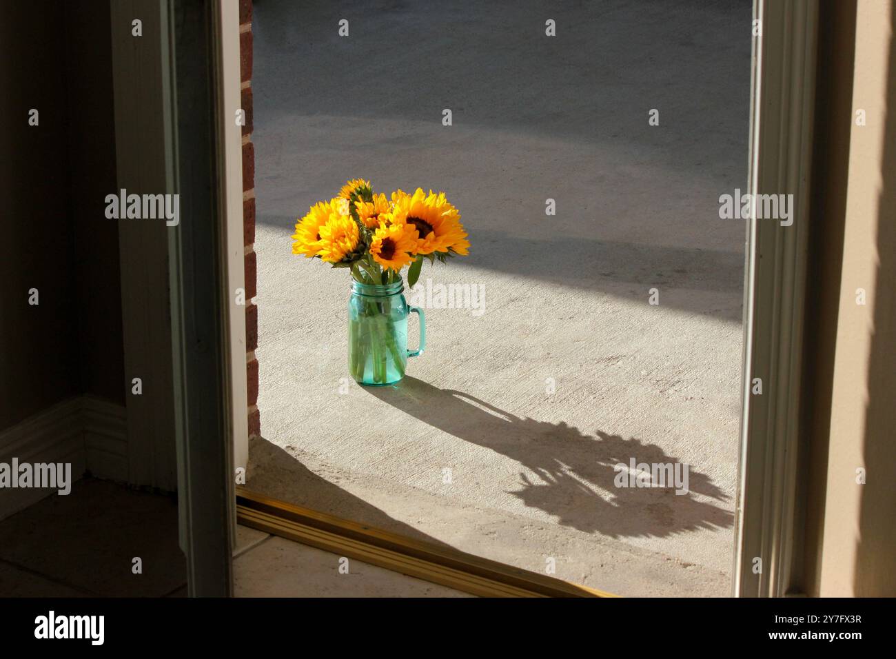 Bouquet giallo tramonto di girasole ombra attraverso una porta Foto Stock