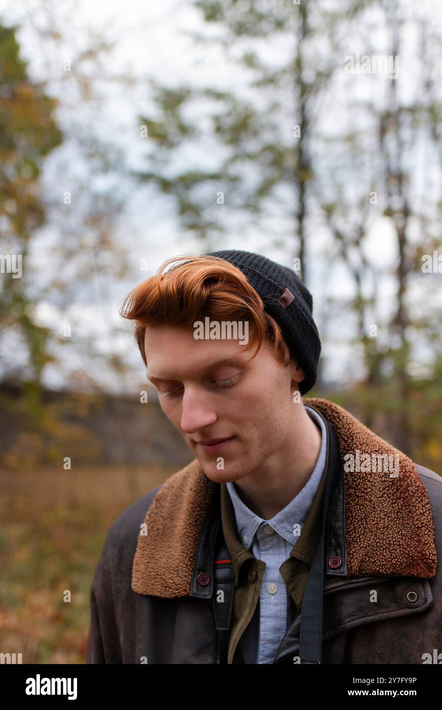 un uomo con i capelli di zenzero si vede indossare un berretto e una giacca calda Foto Stock