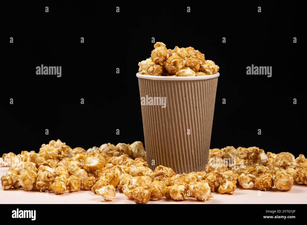 Pop corn dolce caramellato in un secchio. Sfondo nero. Posiziona per testo. Foto Stock