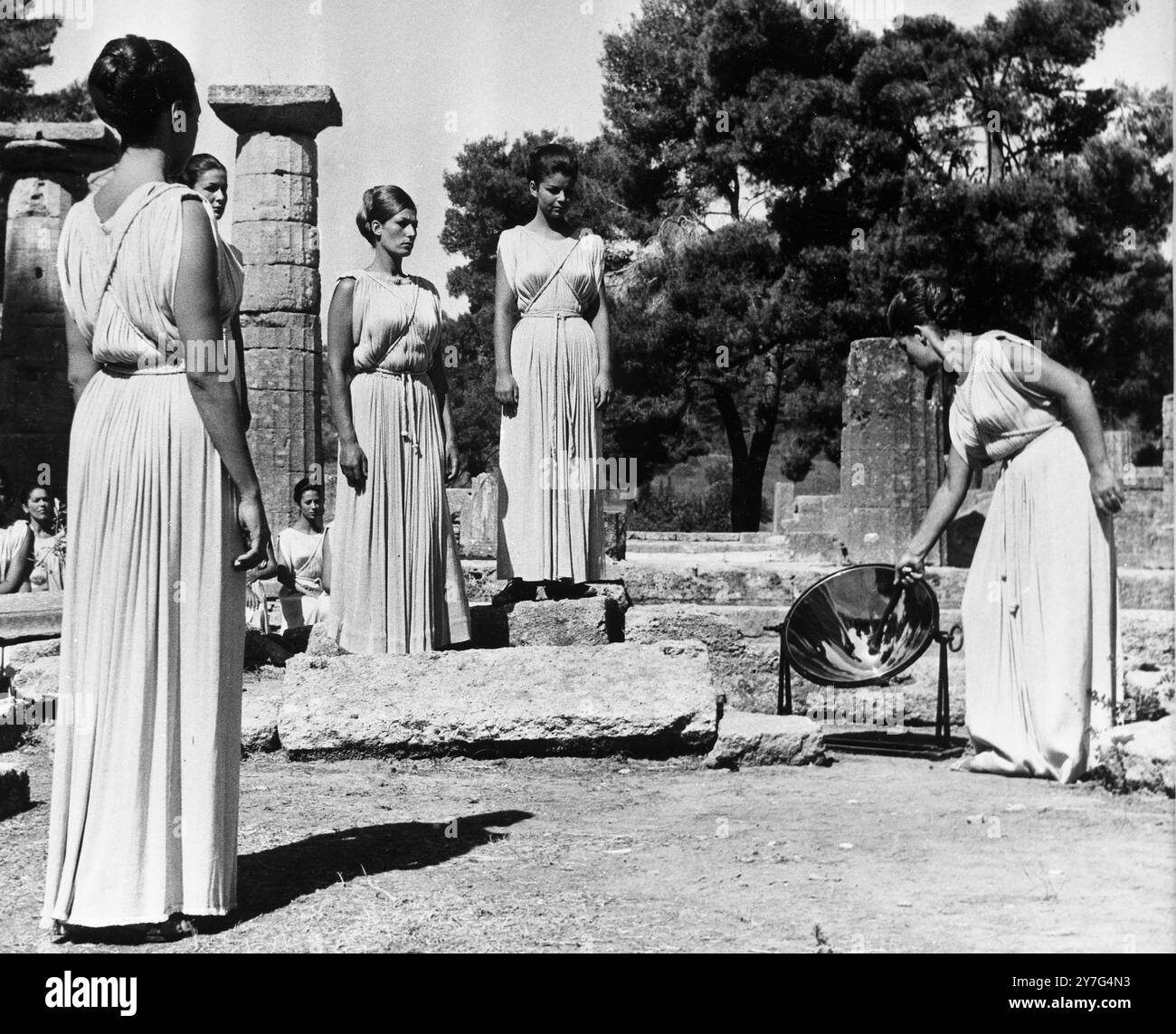 Alta sacerdotessa Aleca Katselli , attrice del Teatro Nazionale Greco durante le cerimonie di illuminazione circondata da altre sacerdotesse ( tutte senza nome ) . Si vede passare la torcia olimpica al velocista greco Evangelos Marcellus . - - - 20 agosto 1964 Foto Stock