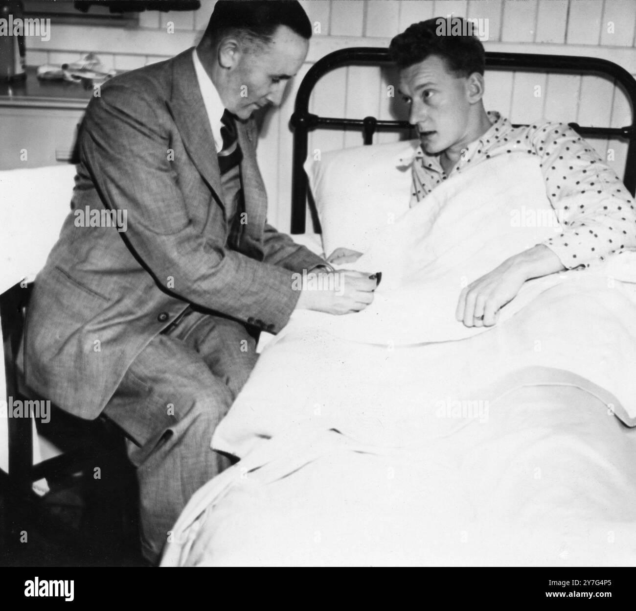 George Avery ( salta salta e salta ) malato di lieve influenza riceve un'aspirina dal team manager Mr Edgar Tanner , nell'ospedale del campo . 25 giugno 1948 Foto Stock