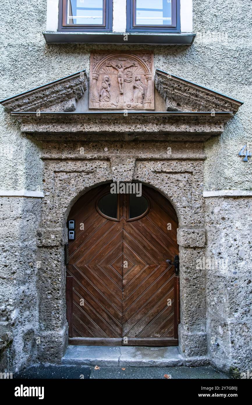 Rilievo in marmo con scena di crocifissione sopra il portale d'ingresso della Stumpfeggerhaus, nel centro storico di Salisburgo, Austria. Foto Stock