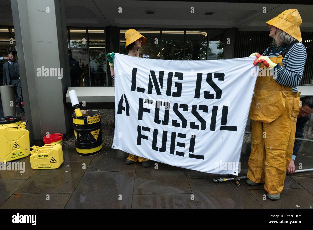 Londra, Regno Unito. 30 settembre 2024. Gli attivisti di "Ocean Rebellion" e "The Yes Men" organizzano una protesta teatrale presso gli uffici dell'Organizzazione marittima internazionale (IMO), invitando l'ente marittimo a smettere di incoraggiare l'uso del gas naturale liquido (GNL). Con lo "Scrubby", una spugna verde gigante, esplosioni di gas ardenti e un gruppo di Merfolk, l'azione ha messo in luce il crescente uso del GNL nel trasporto marittimo come contributo al riscaldamento globale che deve essere ridotto. La protesta è coincisa con la 82a riunione del Comitato per la protezione dell'ambiente marino. Crediti: Ron Fassbender/Alamy Live News Foto Stock