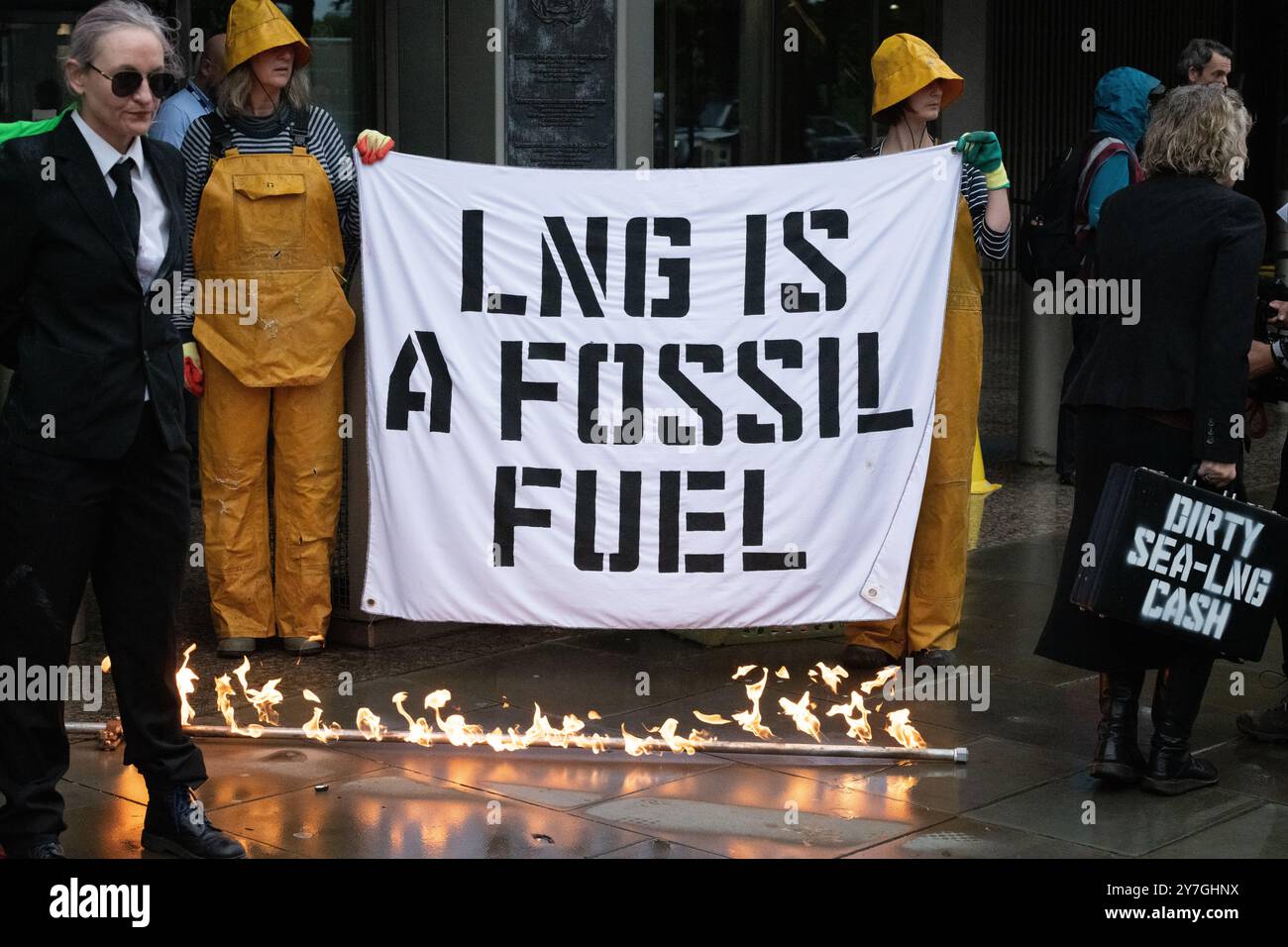 Londra, Regno Unito. 30 settembre 2024. Gli attivisti di "Ocean Rebellion" e "The Yes Men" organizzano una protesta teatrale presso gli uffici dell'Organizzazione marittima internazionale (IMO), invitando l'ente marittimo a smettere di incoraggiare l'uso del gas naturale liquido (GNL). Con lo "Scrubby", una spugna verde gigante, esplosioni di gas ardenti e un gruppo di Merfolk, l'azione ha messo in luce il crescente uso del GNL nel trasporto marittimo come contributo al riscaldamento globale che deve essere ridotto. La protesta è coincisa con la 82a riunione del Comitato per la protezione dell'ambiente marino. Crediti: Ron Fassbender/Alamy Live News Foto Stock