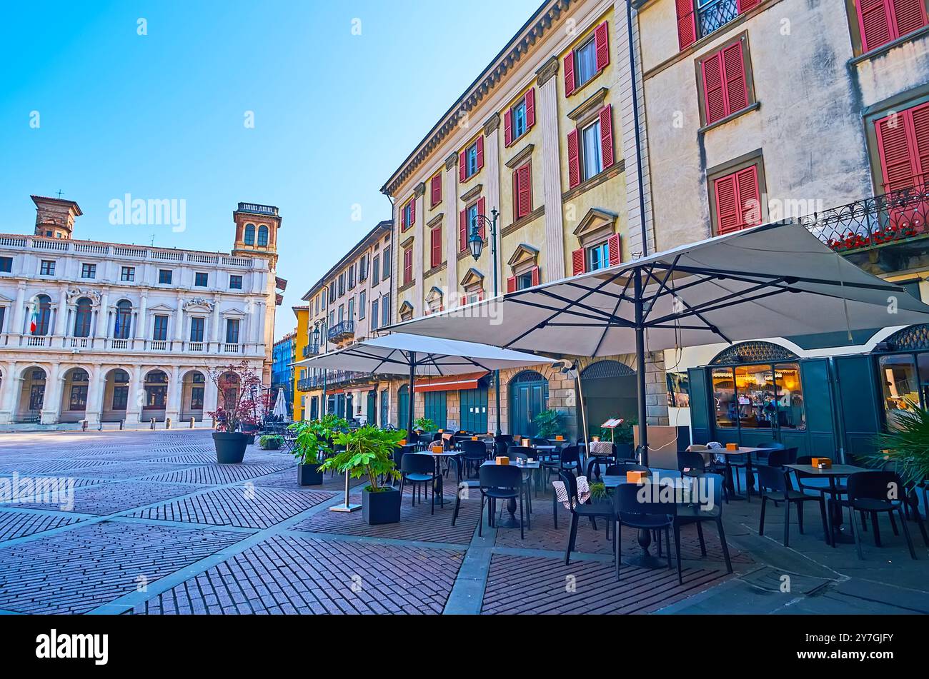 L'accogliente ristorante all'aperto in Piazza Vecchia di fronte alle storiche residenze cittadine e al Palazzo nuovo di Bergamo Foto Stock