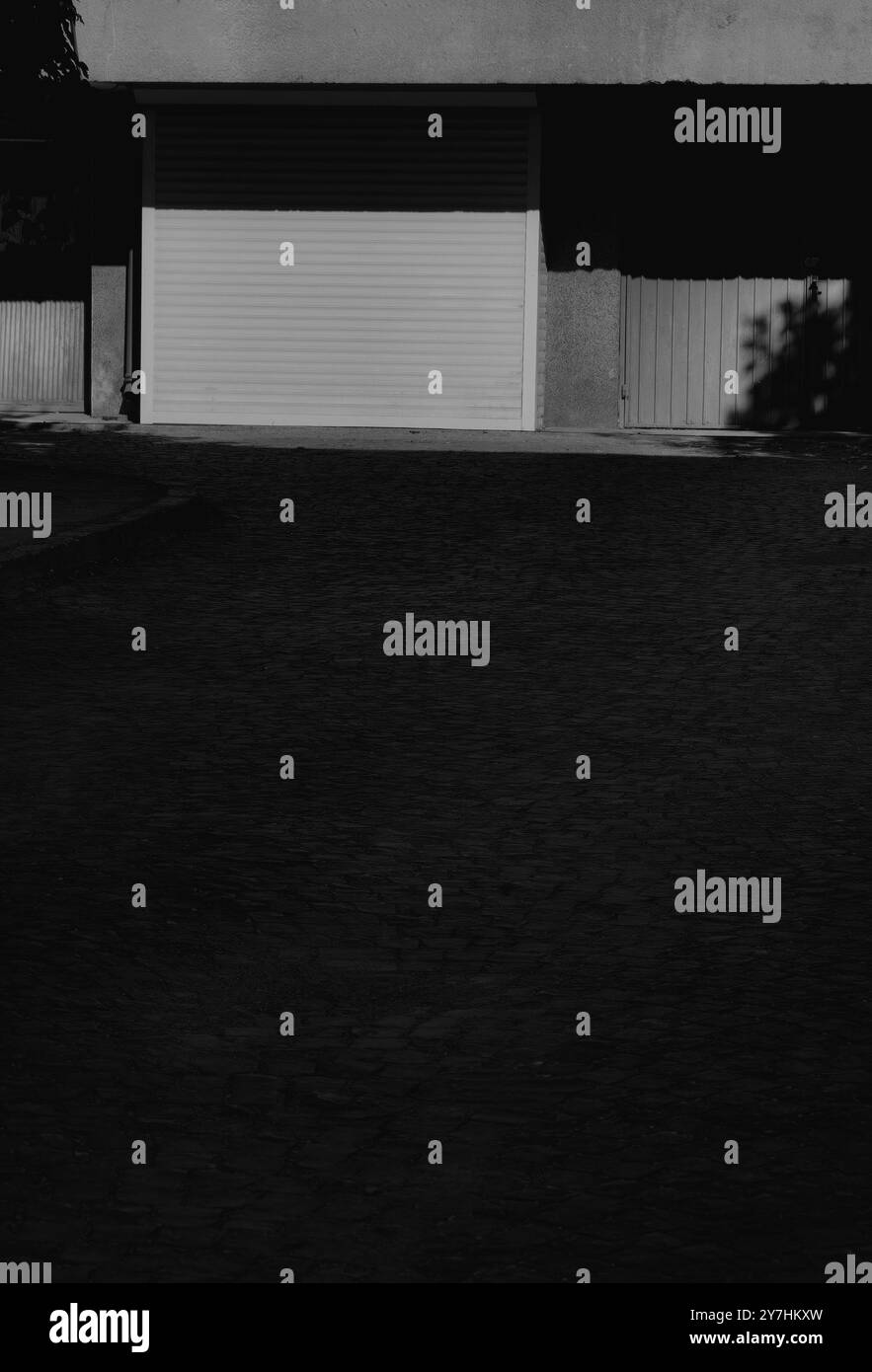 Telaio porta garage chiuso con superficie in ciottoli – minimalismo urbano Foto Stock