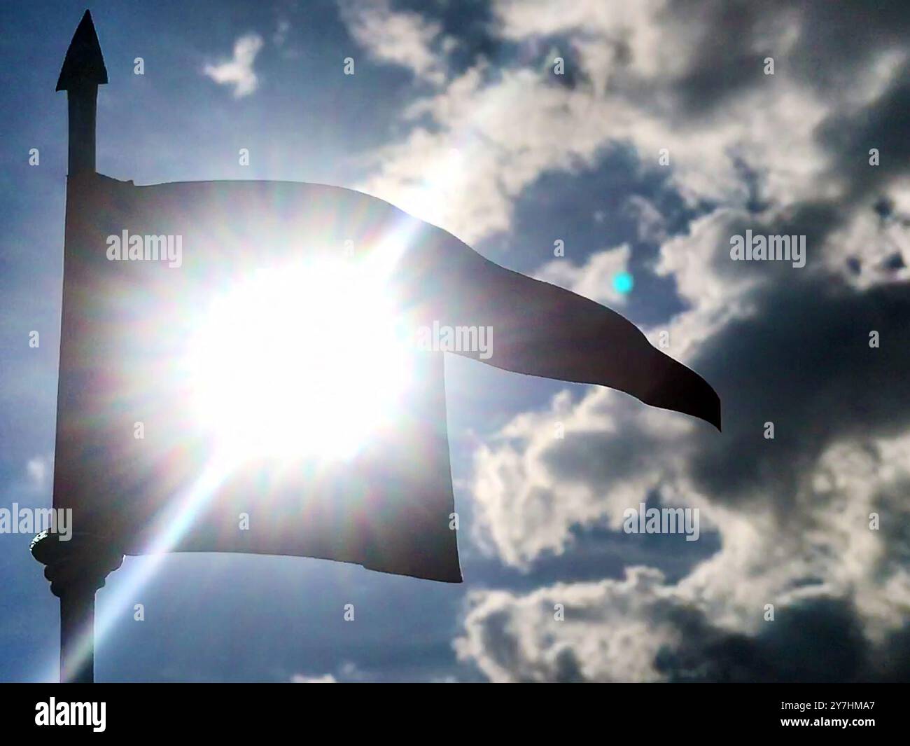 Silhouette di una bandiera storica con un sole splendente Foto Stock