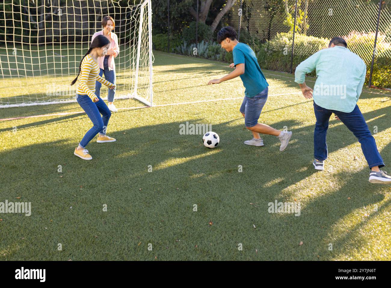 Giocare a calcio sul campo, fare attività all'aperto in famiglia nel parco Foto Stock