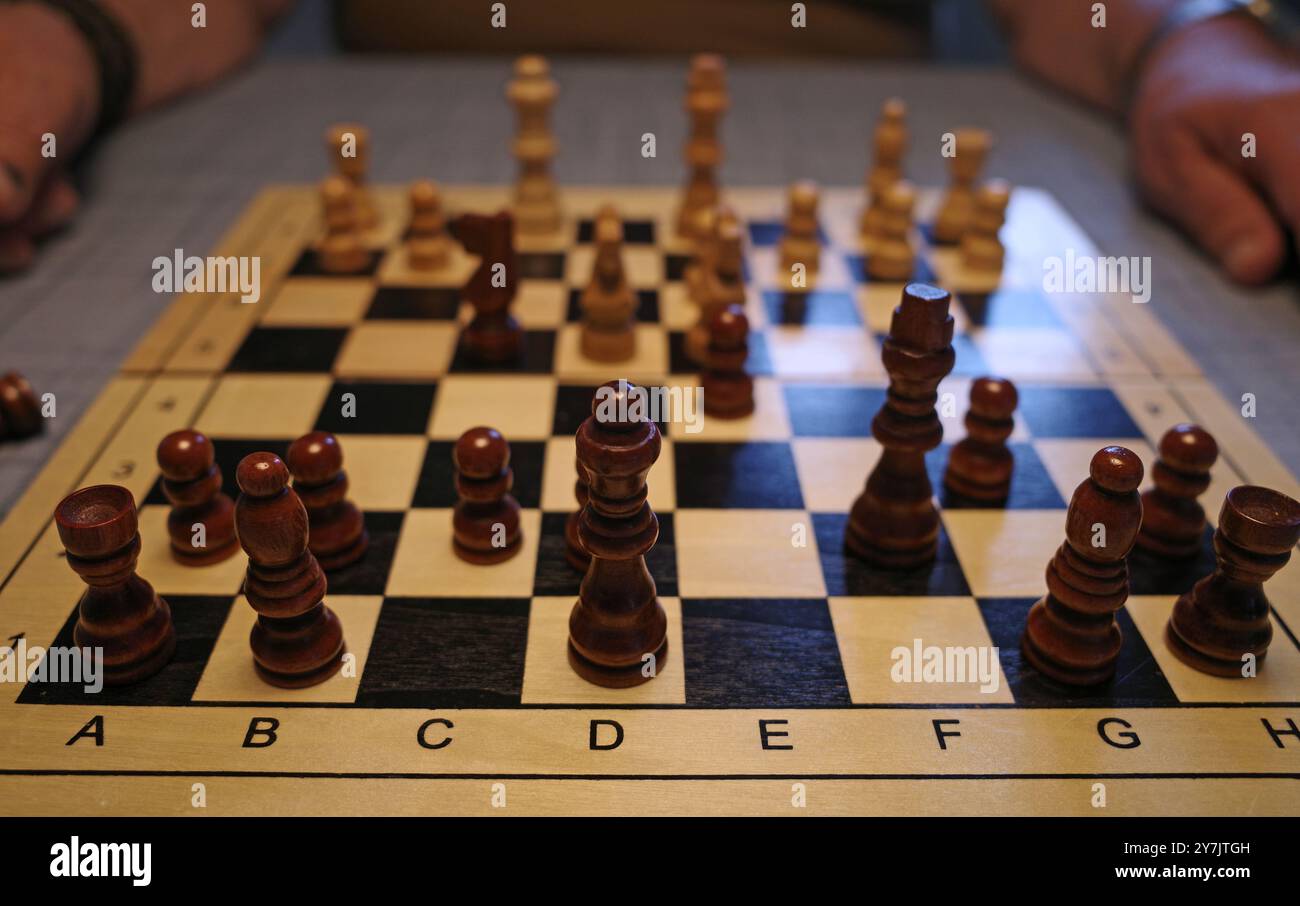 La scacchiera vista dagli occhi di un giocatore che gioca con il nero. Le mani dell'uomo che gioca con il bianco possono essere viste sfocate sullo sfondo Foto Stock