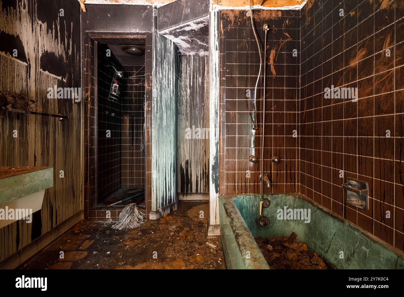 Un bagno danneggiato dal fuoco all'interno di una casa abbandonata con pareti oscurate. Questa casa è stata demolita da allora. Foto Stock