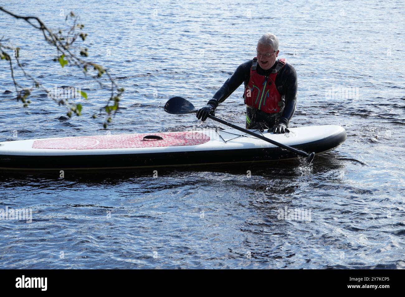 Uomo che impara a pagaiare (SUPB) a Loch Rannoch in Scozia, Regno Unito Foto Stock