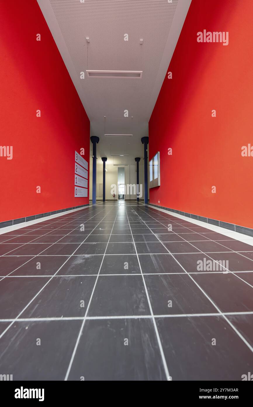 Lungo corridoio con pareti rosse e pavimento piastrellato nero, Università di Stoccarda, Germania, Europa Foto Stock