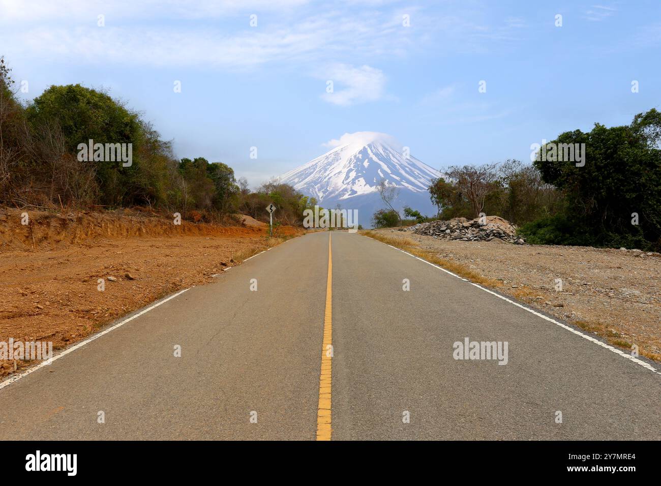 Una strada di montagna vuota in una giornata limpida con vista sul Monte Fuji sullo sfondo. Foto Stock