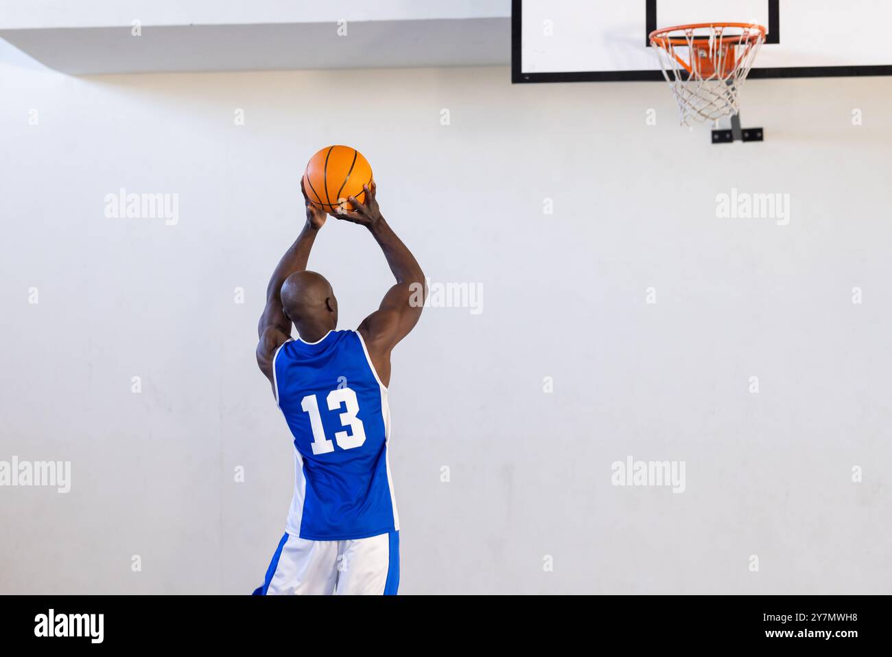Giocare a basket, atleta con maglia blu che tira la palla verso il cerchio, copia spazio Foto Stock