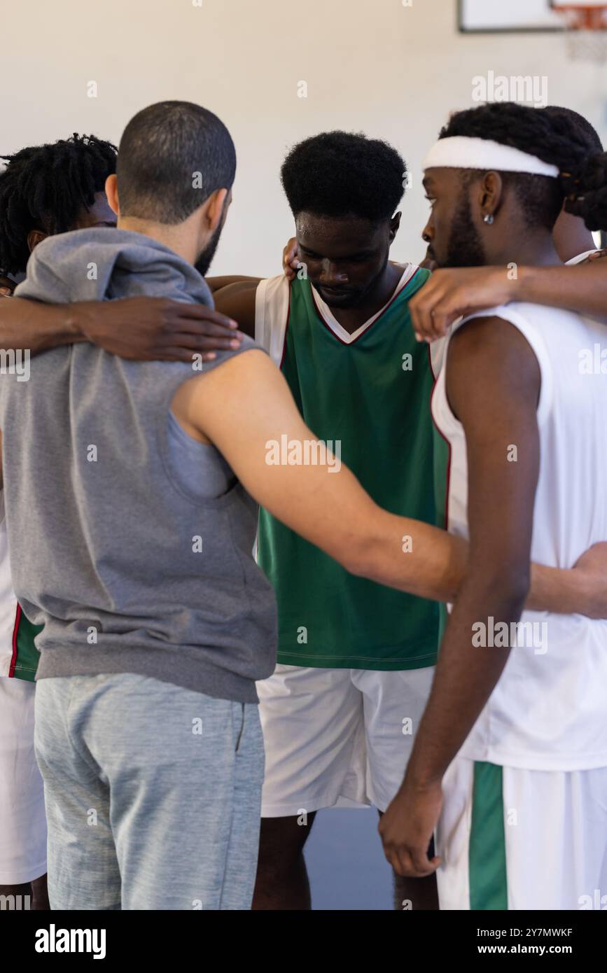 Abbracciare e organizzare strategie, legare la squadra di basket prima della partita Foto Stock