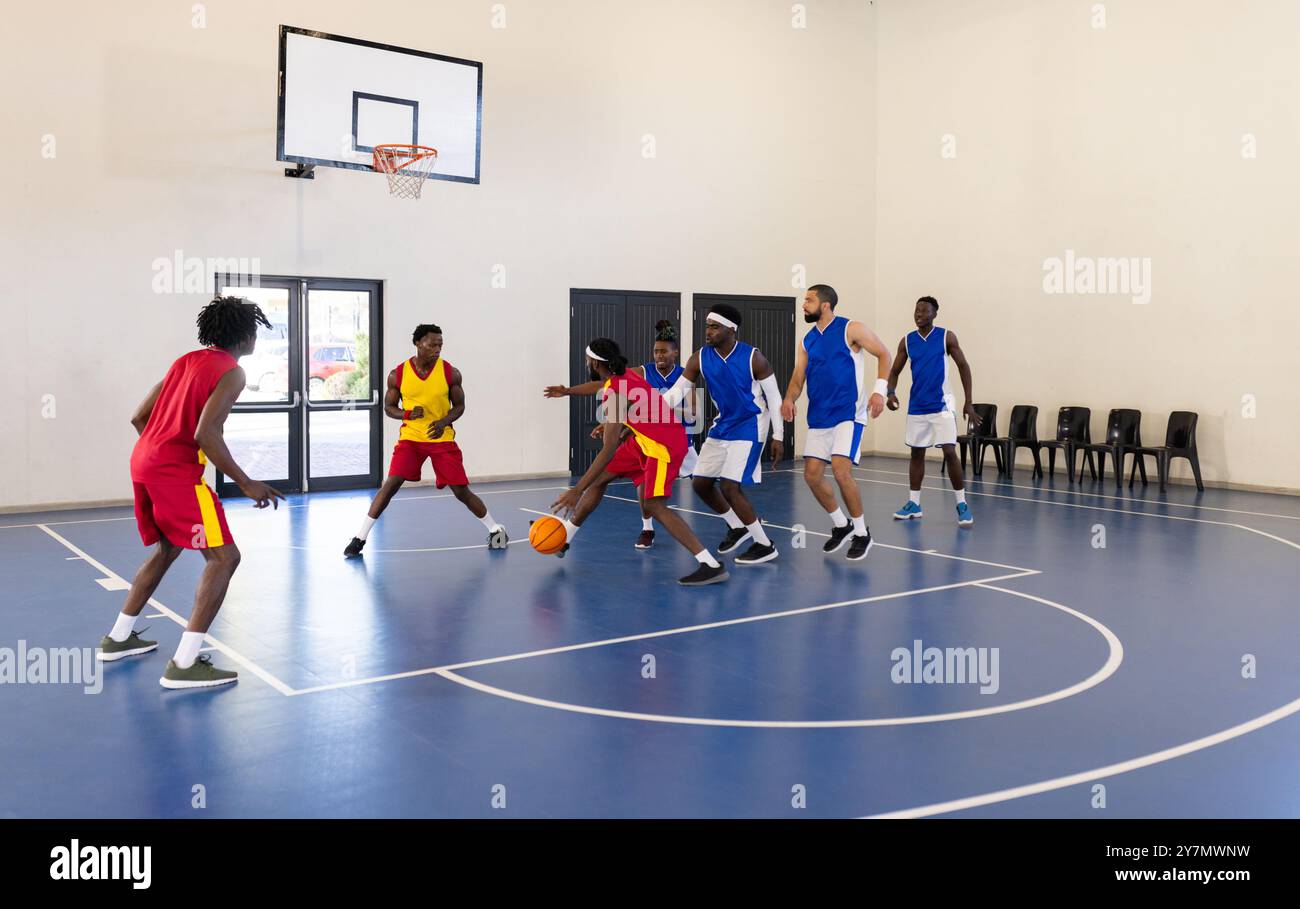 Giocare a basket, squadra in uniformi rosse dribbling e difesa contro la squadra blu Foto Stock