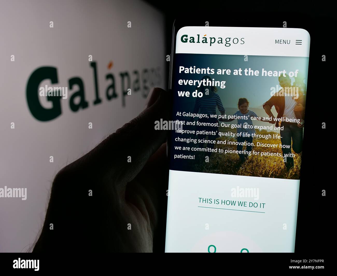 Persona che detiene lo smartphone con la pagina web dell'azienda farmaceutica belga Galapagos NV sullo schermo con il logo. Messa a fuoco al centro del display del telefono. Foto Stock