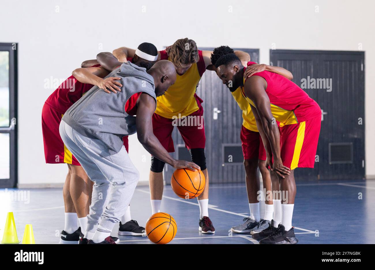 Diversi giocatori di pallacanestro si sono accontentati e hanno una strategia sul campo al coperto con l'allenatore Foto Stock