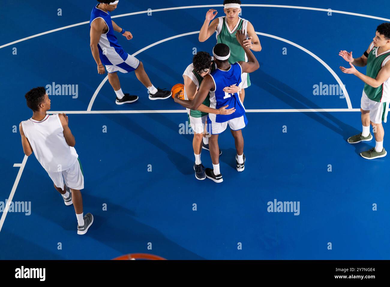 Giocando a basket, giocatori con maglie blu e verdi in competizione sul campo Foto Stock