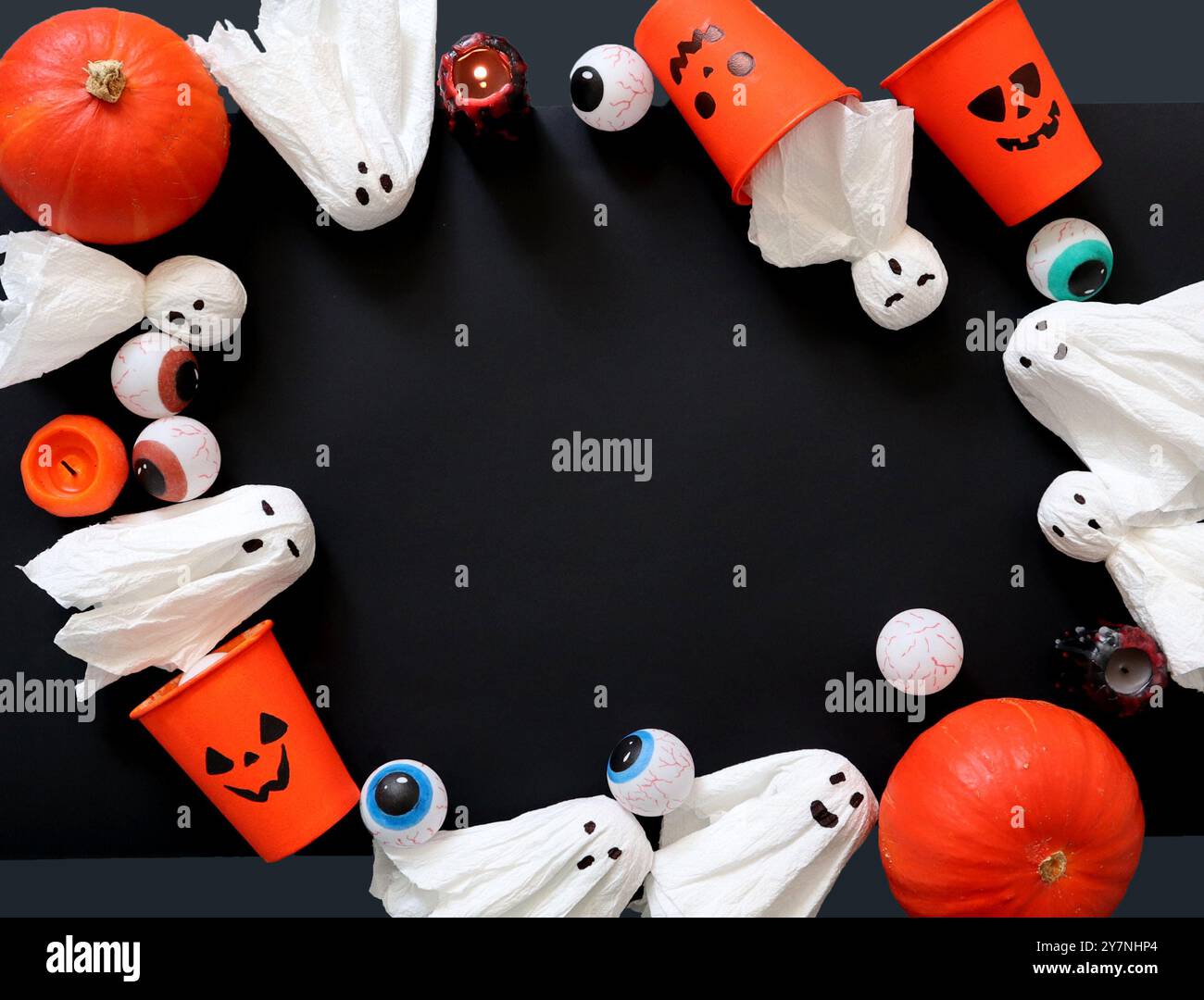 Cornice di vari elementi decorativi per Halloween. Zucche, occhi dipinti. Fantasmi dai tovaglioli. Gli occhiali sono dipinti in Jack o'Lantern. Candele. Nero c Foto Stock