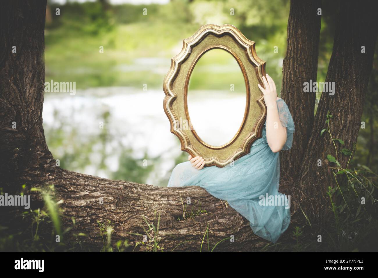 donna che tiene uno specchio che riflette la natura dietro il concetto astratto Foto Stock