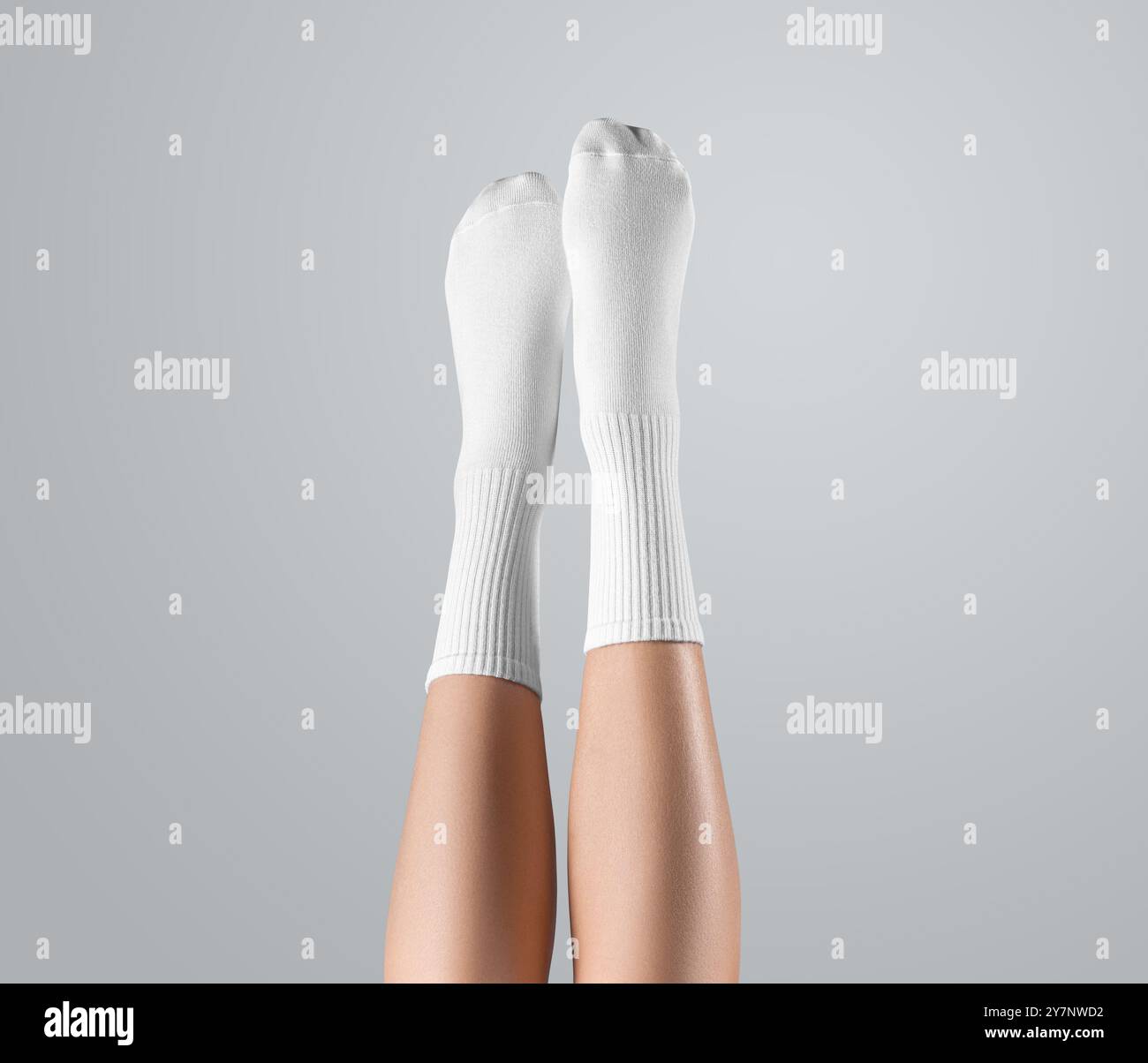Modello di calze alte bianche sui bellissimi piedi delle donne, con dita allungate, gambe di presentazione in alto, parte anteriore, isolata sullo sfondo. Mockup di ghette acceso Foto Stock