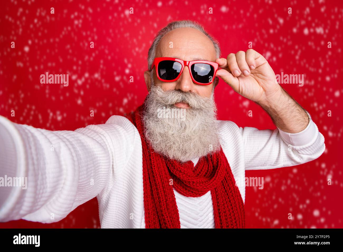 La moda di età compresa tra santa uomo rendendo self foto usura sun specs ponticello a maglia isolato sfondo rosso Foto Stock