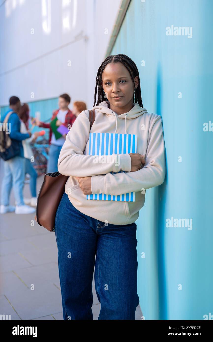 Felice giovane studentessa afroamericana con un notebook guarda la macchina fotografica Foto Stock