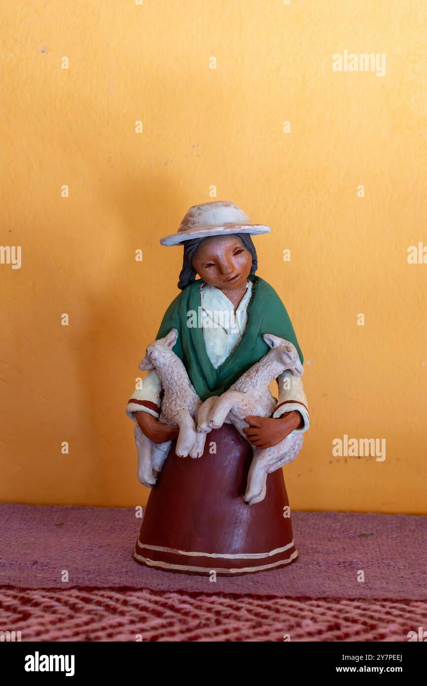 Una donna Aymara in ceramica con agnelli di Santina Alabar, artista ceramico indigena Aymara, a Purmamarca, Argentina. Foto Stock