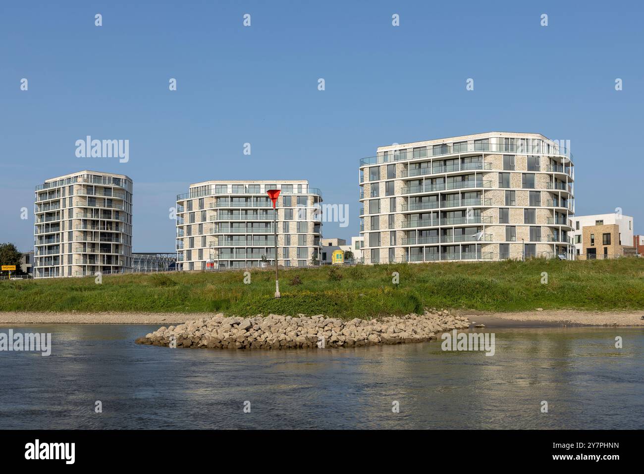 Si innalzano le facciate esterne di lussuosi edifici di appartamenti di nuova costruzione lungo il fiume IJssel visti dall'acqua. Ingegneria e sviluppo urbano Foto Stock