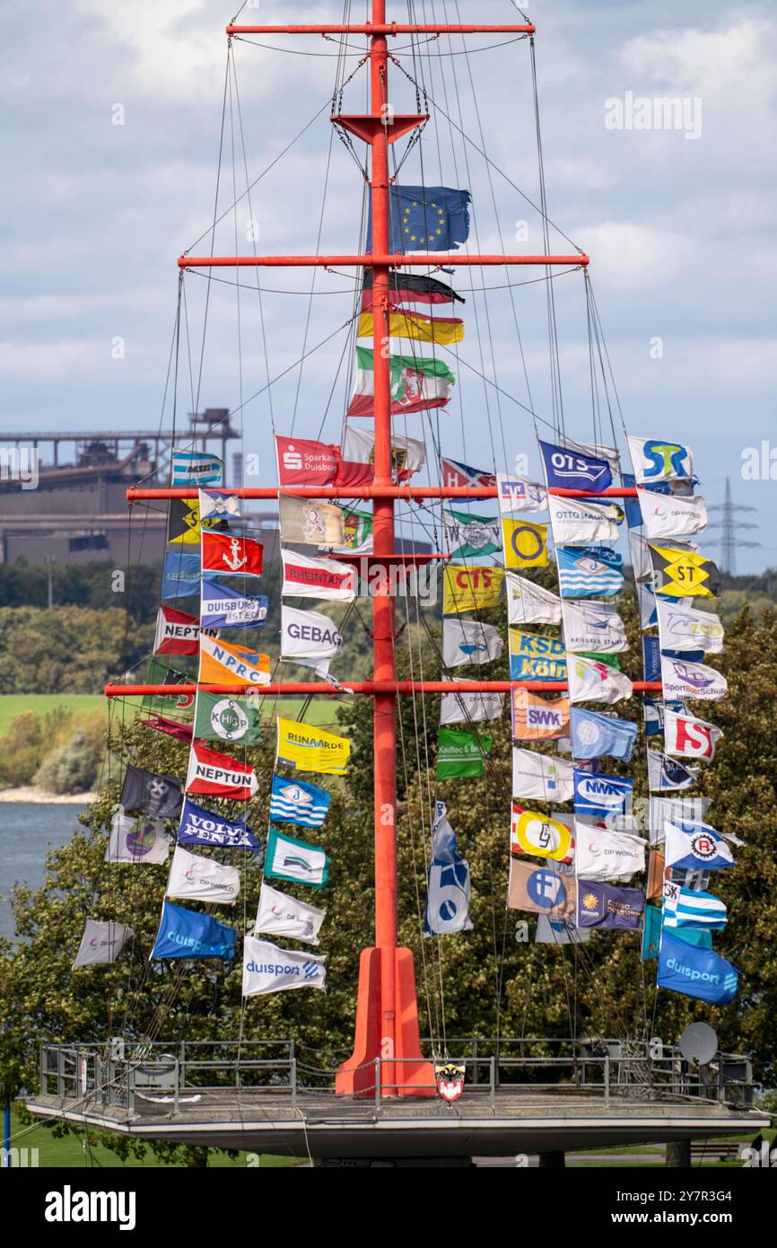 Flaggenmast auf der Mühlenweide, am Rhein, 38 metri hohe originalgetreue Nachbildung des Mastes eines Rah-Seglers, mit vielen Flaggen aus der Binnenschifffahrt bestückt, Duisburg, NRW, Deutschland, Binnenschiffahrt *** Flagpole sul Mühlenweide, sul Reno, replica fedele di 38 metri di una nave a vela Rah, navigazione interna equipaggiata con molte bandiere tedesche, navigazione interna, Duisburg, navigazione interna Foto Stock