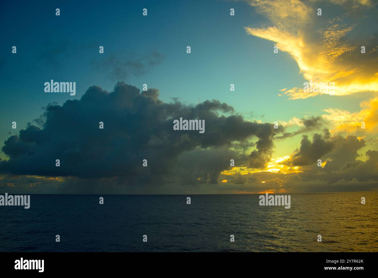 Nuvole pesanti che coprono il sole che tramonta nell'Oceano Pacifico Foto Stock