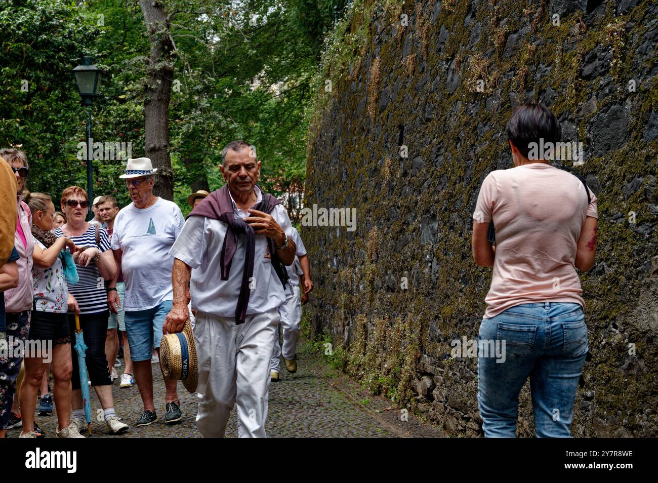 Il carreiro maturo cammina con determinazione attraverso la folla, cappello in mano Foto Stock