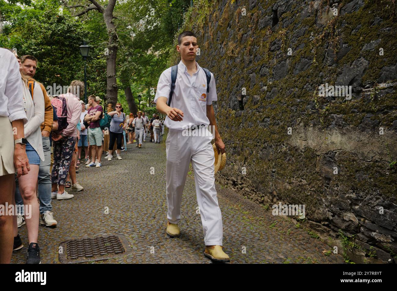 Giovane carreiro cammina tra la folla, cappello in mano e uno sguardo concentrato Foto Stock